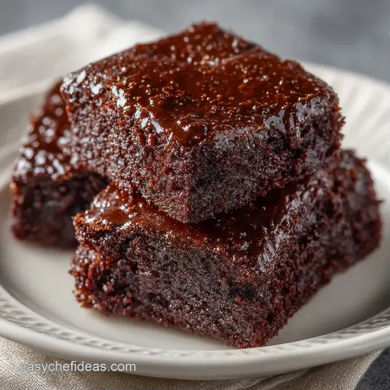 Neat squares of dark chocolate cake stacked elegantly with a dusting of powdered sugar and fresh red berries.