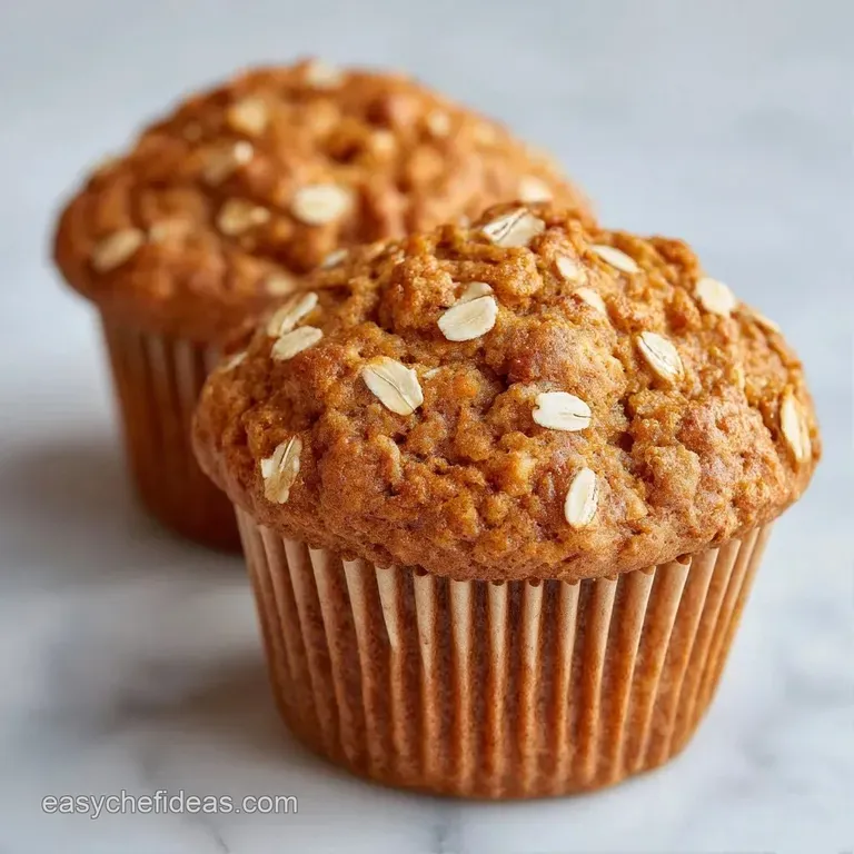 A stack of fluffy golden muffins on a white ceramic plate, garnished with a sprinkle of rolled oats and honey.